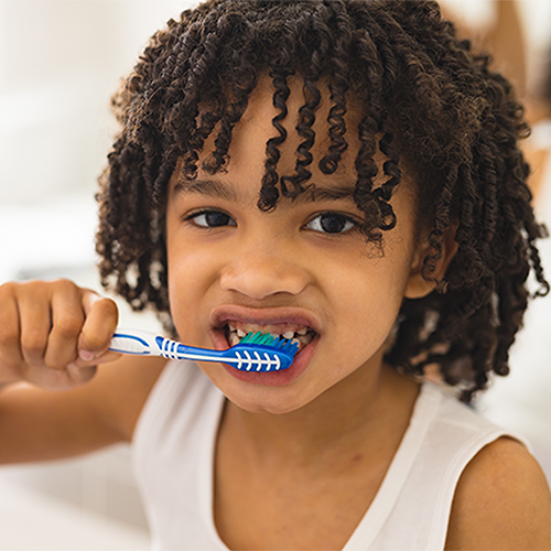 Curly haired boy brushing teeth