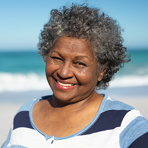 Old woman smiling at the beach